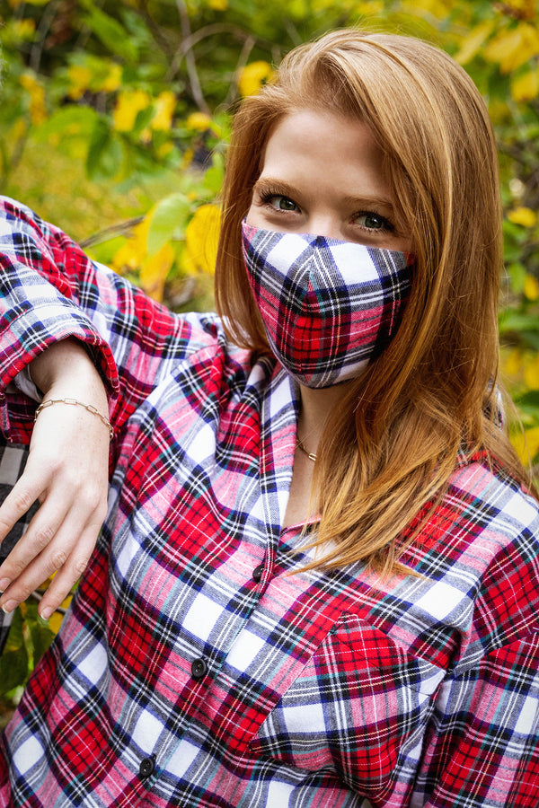 model wearing red tartan face mask with matching pajamas